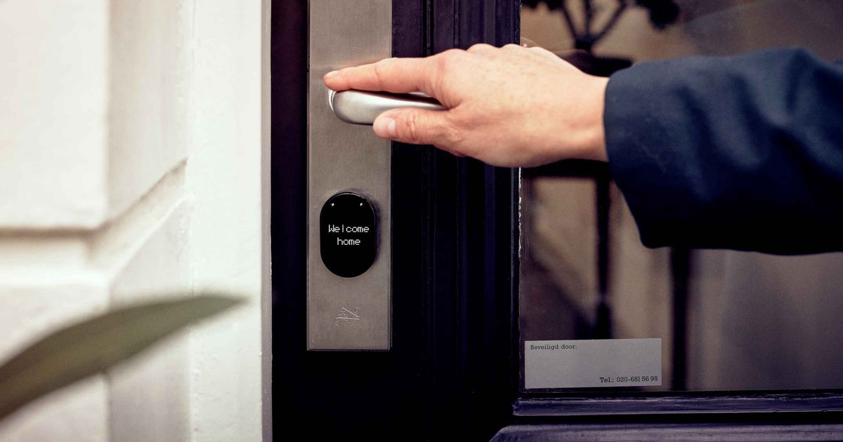Mano abriendo puerta inteligente con panel de acceso digital sin llave