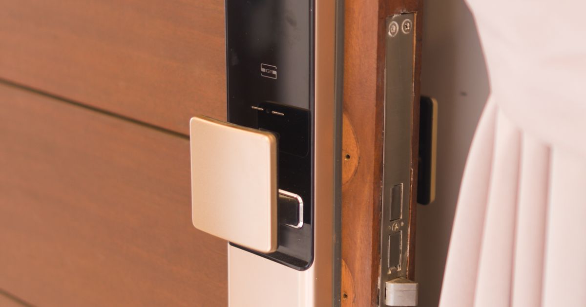 Primer plano de cerradura digital inteligente montada en puerta de madera